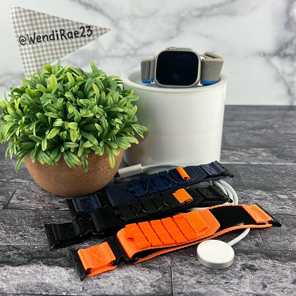 Apple Watch Ultra 49mm with charger base and four straps